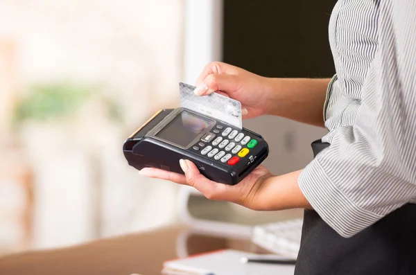 Primo piano della macchina della carta di credito, una mano di donna che scambia una carta grigia — Foto Stock