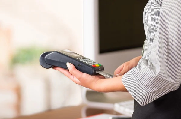 Credit card machine die door de handen van de vrouw, een grijze kaart invoeren onder de machine, close-up — Stockfoto