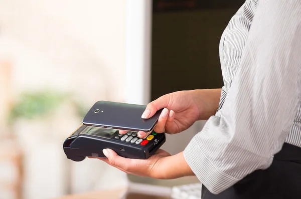Telefone celular inteligente perto de uma máquina de cartão de crédito, as contas podem ser pagas desta forma — Fotografia de Stock