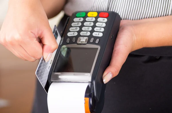 Frau hält einen Kreditkartenzahlungsautomaten in der Hand, weißes Papier kommt heraus und Kreditkartentausch — Stockfoto