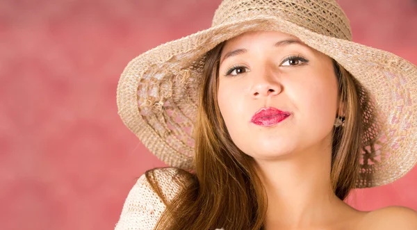 Mulher séria com um belo chapéu de malha na cor bege posando em um fundo rosa — Fotografia de Stock