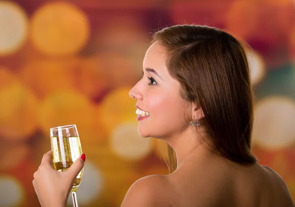 Mujer de la espalda sosteniendo con la mano una copa de champán — Foto de Stock