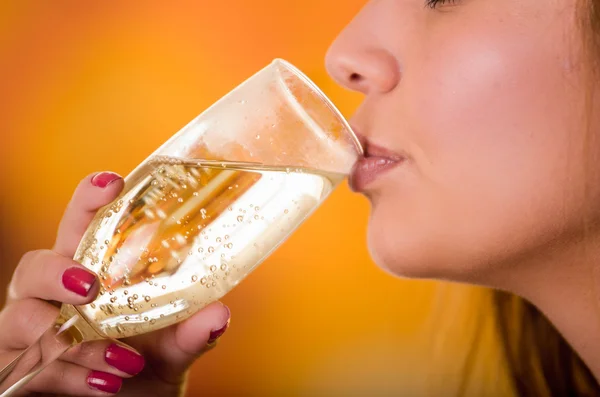 Close up de copo de champanhe segurando por uma mão unhas vermelhas e lábios bonitos — Fotografia de Stock