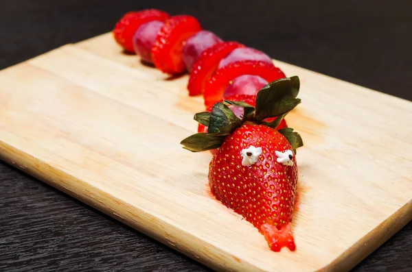 Retrato de serpiente de aspecto divertido hecho de fresas y uvas en rodajas — Foto de Stock