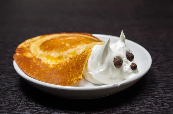 Funny looking turtle portrait made from pancake and cream with chocolate eyes, lying on white plate — Stock Photo, Image