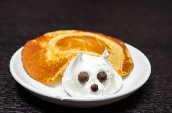 Funny looking turtle portrait made from pancake and cream with chocolate eyes, lying on white plate — Stock Photo, Image