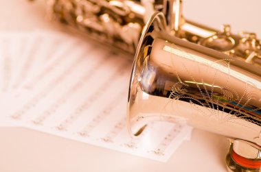 Kısmen closeup görüntülemek parlak saksafon müzik notaları kağıt üzerinde yalan