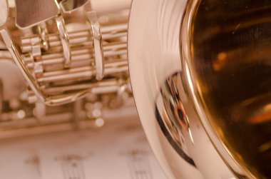 Kısmen closeup görüntülemek parlak saksafon müzik notaları kağıt üzerinde yalan
