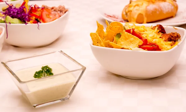 Selezione di diversi piatti deliziosi seduti su tavolo bianco, panino Philadelphia, insalata tortilla — Foto Stock