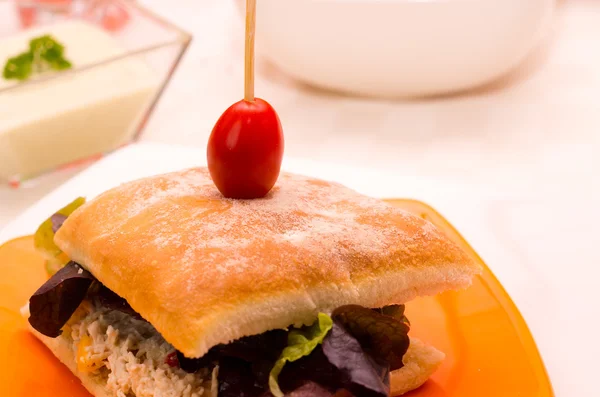 Delicioso sándwich de ciabatta con tapa de tomate cherry pincho, sentado en un plato blanco, concepto de catering —  Fotos de Stock