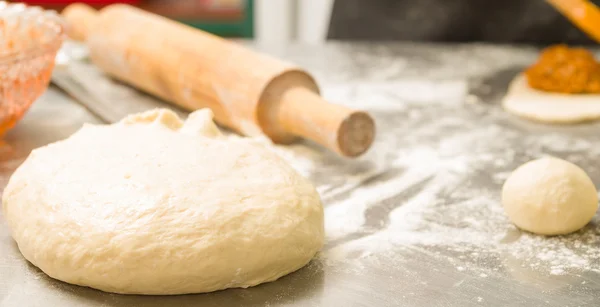 Primo piano deliziosa pasta di pane a forma di palla prima della cottura, mattarello sfondo — Foto Stock