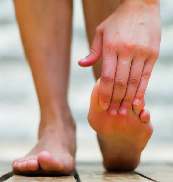 Voet zijn belangrijk om gezond te zijn, massage voet op de tiptoe. Houten vloer — Stockfoto