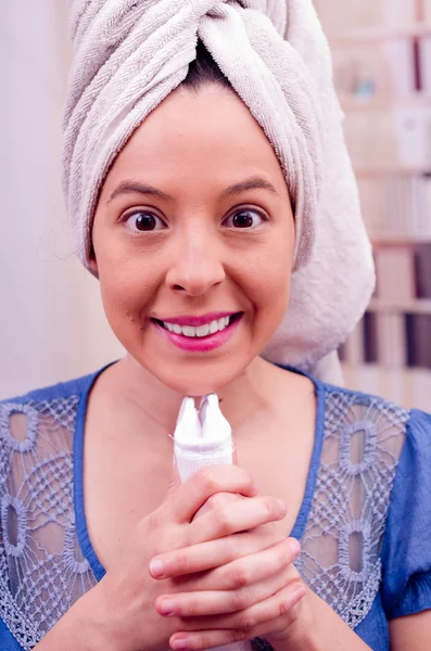 Glückliche junge Frau nach der Gesichtsreinigung mit einem Handtuch in der Hand — Stockfoto