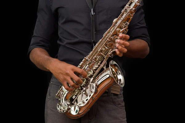 Mooie handen aanraken van een zilveren saxofoon, zwarte achtergrond — Stockfoto
