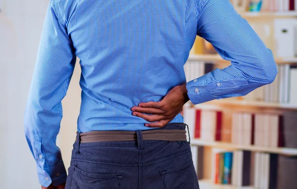 Man vidrör ryggen med en av hans hand, ryggvärk — Stockfoto