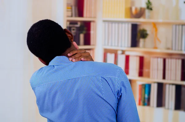 Człowiek w biurze, dotykając jego szyi z jego ręki, ból jest powszechne w biurach — Zdjęcie stockowe
