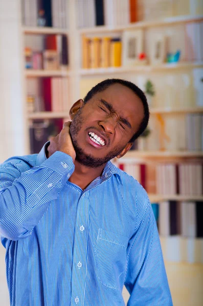 Man suffering a strong pain in his neck, unhappy gace with his hand on his neck — Stock Photo, Image