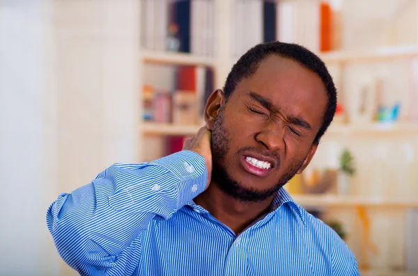 Close up of man face suffering because of neck pain, his hand on his neck and closed eyes — Stock Photo, Image