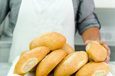 Taze ekmek yığını loafs, arkasında duran sadece apren ve silah görünür, ekmek kavramı ile baker