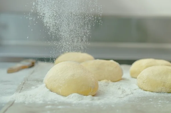 Läckra bröd deg bullar sitter på metall yta med mjöl som stänkte som toppning innan bakning — Stockfoto