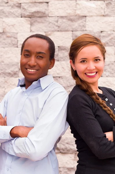Beautiful interracial couple posing, rubbing shoulders and smiling for camera — Stock Photo, Image