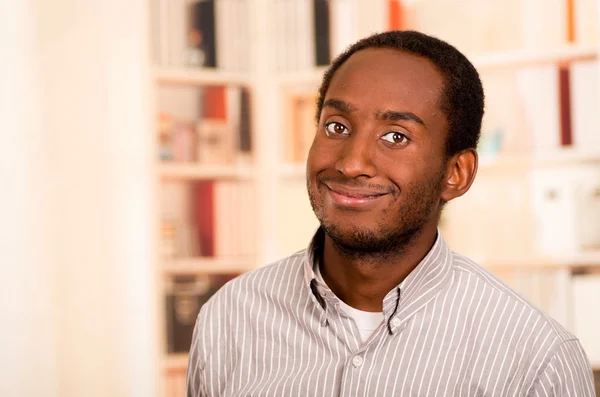 Beau homme portant des vêtements décontractés posant souriant pour appareil photo, fond de bibliothèque blanc — Photo