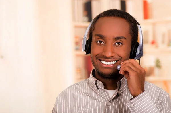 Beau homme portant des vêtements décontractés et casque avec microphone, grande attitude positive souriant à la caméra — Photo