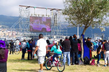 Quito, Ekvador - 7 Temmuz 2015: Papa Francisco'nun Ekvador'daki ayinin etrafında yaptığı küçük yolu büyük ekrana bakan insanlar