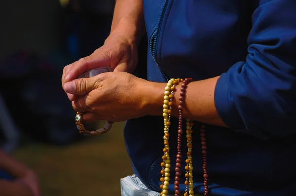 QUITO, ECUADOR - JULY 7, 2015: Old hands with prayer beads of different colors, pope Francisco mass on Ecuador