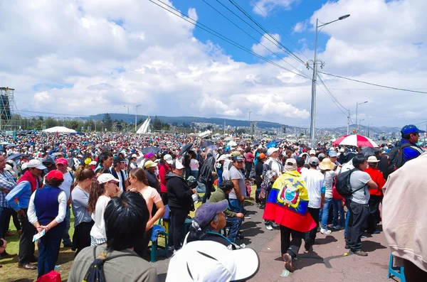 QUITO, ECUADOR - 7 DE JULIO DE 2015: Un gran lugar lleno de gente, la misa del Papa Francisco en Ecuador. Ropa colorida y sombrillas —  Fotos de Stock