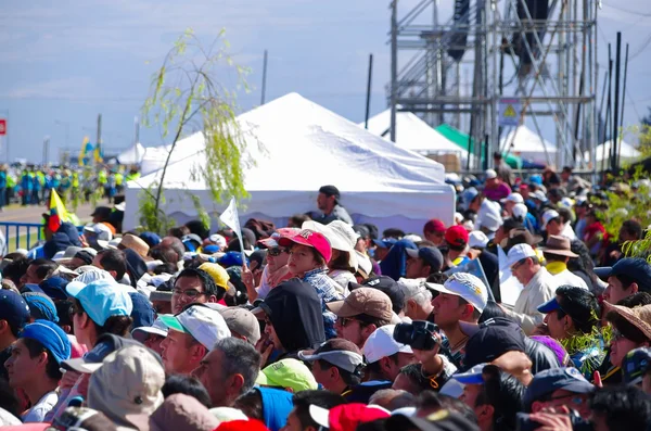 QUITO, ECUADOR - 7 DE JULIO DE 2015: Mucha gente con sombreros y gorras esperando ver al Papa Francisco, tiendas detrás. Día soleado — Foto de Stock