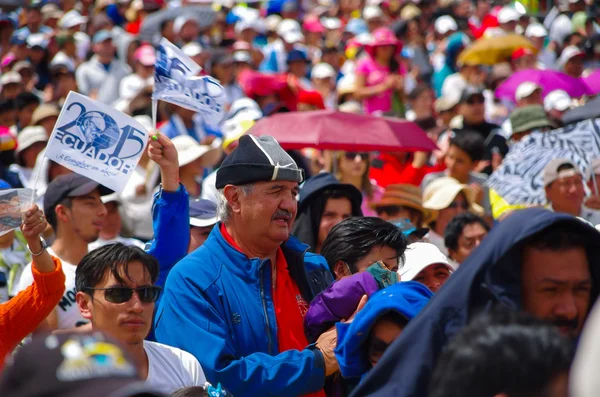 QUITO, ECUADOR - 7 DE JULIO DE 2015: En medio de mil personas, un hombre grande con tirón azul está rezando, sosteniendo una chaqueta —  Fotos de Stock