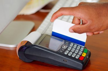 Ahşap yüzeyüzerinde oturan ödeme terminali cihazı ile kredi kartını çekme