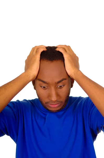 Headshot gestrest man dragen sterke blauw gekleurde t-shirt met behulp van handen aanraken van zijn eigen hoofd gefrustreerd, witte studio achtergrond — Stockfoto