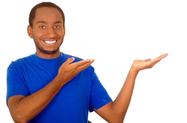 Άνθρωπος φορώντας ισχυρό μπλε t-shirt στέκεται και αλληλεπιδρά χρησιμοποιώντας τα χέρια προσομοιώνοντας την παρουσίαση, ενώ χαμογελαστά, λευκό φόντο στούντιο — Φωτογραφία Αρχείου