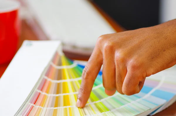 Mãos de close-up segurando paleta, colormap espalhados na frente do teclado do computador branco, conceito de designer — Fotografia de Stock