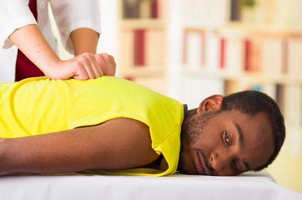 Homem recebendo tratamento físico de fisioterapeuta, suas mãos trabalhando em suas costas e aplicação de massagem, conceito médico — Fotografia de Stock