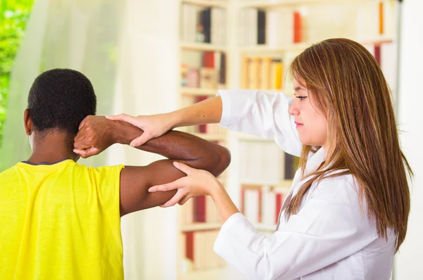 Man får fysisk arm behandling från Physio terapeut, hennes händer arbetar på axeln och armbåge, medicinska koncept — Stockfoto