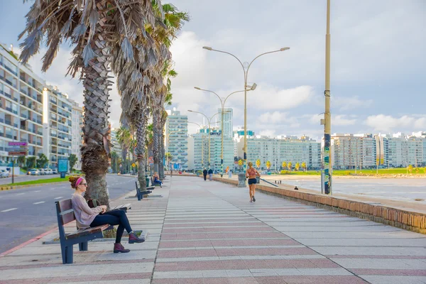 Montevideo, Uruguay - 04 Mayıs 2016: öğleden sonra şehrin arka plan olarak yönetim kurulu sahilde zevk insanlar — Stok fotoğraf