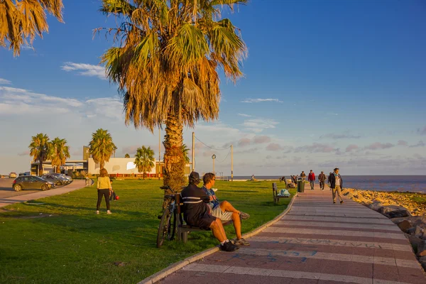 MONTEVIDEO, URUGUAY - 04 DE MAYO DE 2016: buena puesta de sol en la becah, algunas personas disfrutando de la luz del sol y un bonito cielo azul como fondo — Foto de Stock