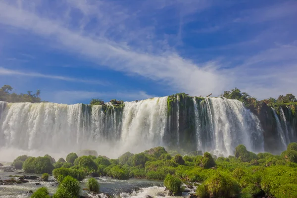 Iguazu, Brazília - 2016. május 14.: szép kilátás az alsó-vízesés, fű, a vízesés és a kék ég háttér előtt hatálya sziklák — Stock Fotó