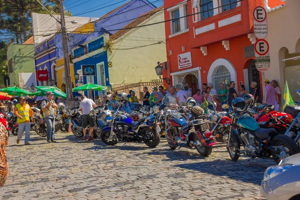CURITIBA ,BRAZIL - MAY 12, 2016: unidentified people lokking to some motorcycles parked in the street close to the square where the marked place is located — Stock Photo, Image