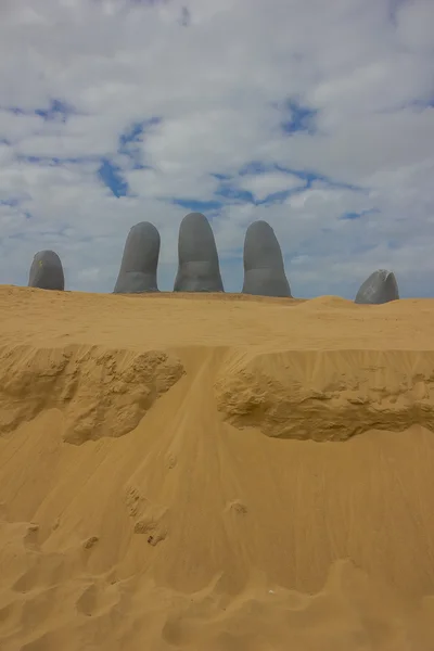 PUNTA DEL ESTE, URUGUAY - MAY 04, 2016: Fem menneskelige fingre kommer ut av sanden, denne skulpturen er også kjent som hånden – stockfoto