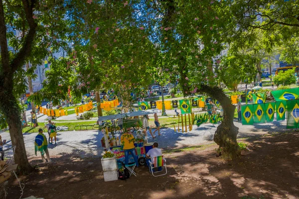 CURITIBA, BRASIL - 12 DE MAYO DE 2016: pequeño vagón de comida ubicado debajo de algunos árboles en el parque rodeado de banderas brasileñas — Foto de Stock