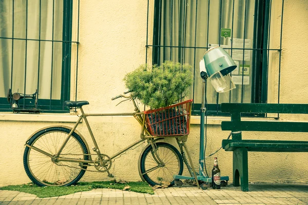 COLONIA DEL SACRAMENTO, URUGUAY - 04 DE MAYO DE 2016: bonita bicicleta obsoleta estacionada fuera de una casa junto a un banco —  Fotos de Stock