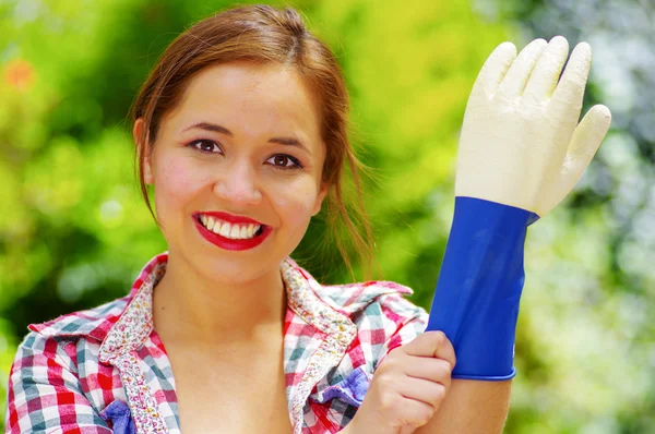 Sol taraftan bir eldiven koyarak Derma gömlek gülümseyen kadın — Stok fotoğraf