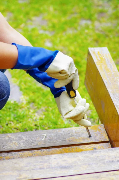 Handen met handschoenen houden een zwarte schroevendraaier — Stockfoto