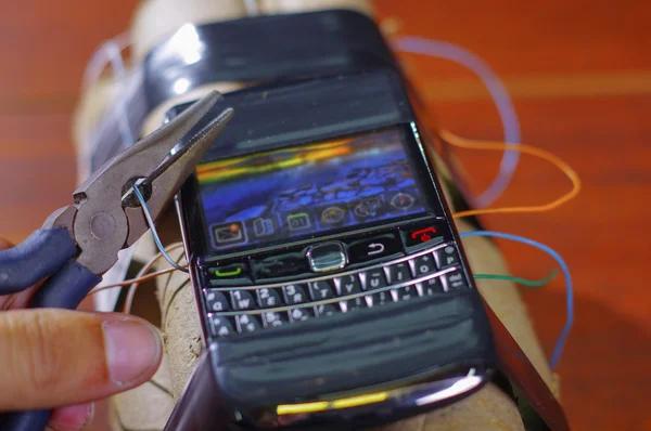 Hand proberen te snijden van de kabel die de mobiele telefoon verbinding te maken met de explosieven — Stockfoto