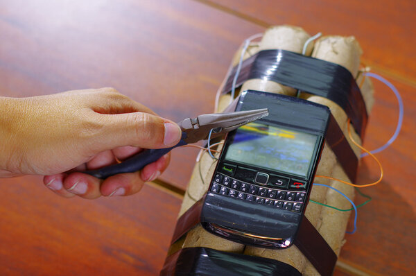 pliers cutting the cable that connects the cell phone to the explosives
