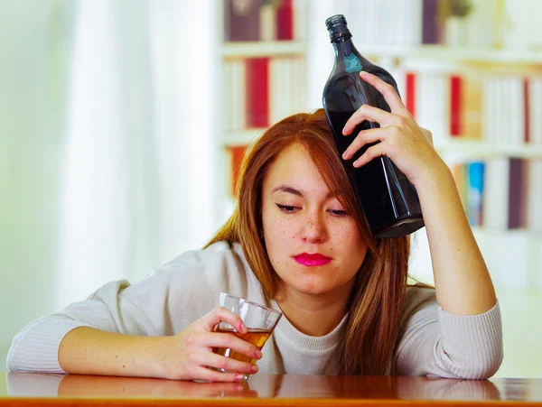 Cam ve şişe tutan kafa, sarhoş depresif yüz ifadesi, alkollü kavramı için Resepsiyon üzerinde yalan sayaç Bar oturarak beyaz kazak giyen kadın